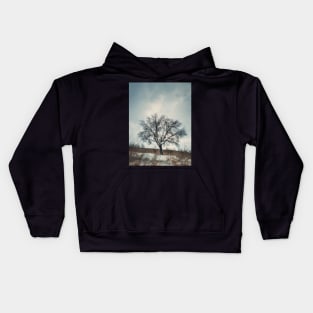 a tree on the snowy hill Kids Hoodie